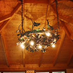 Ručne kovaný dubový luster v letnom altánku - štýlové osvetlenie s motívom prírody - luxusný luster